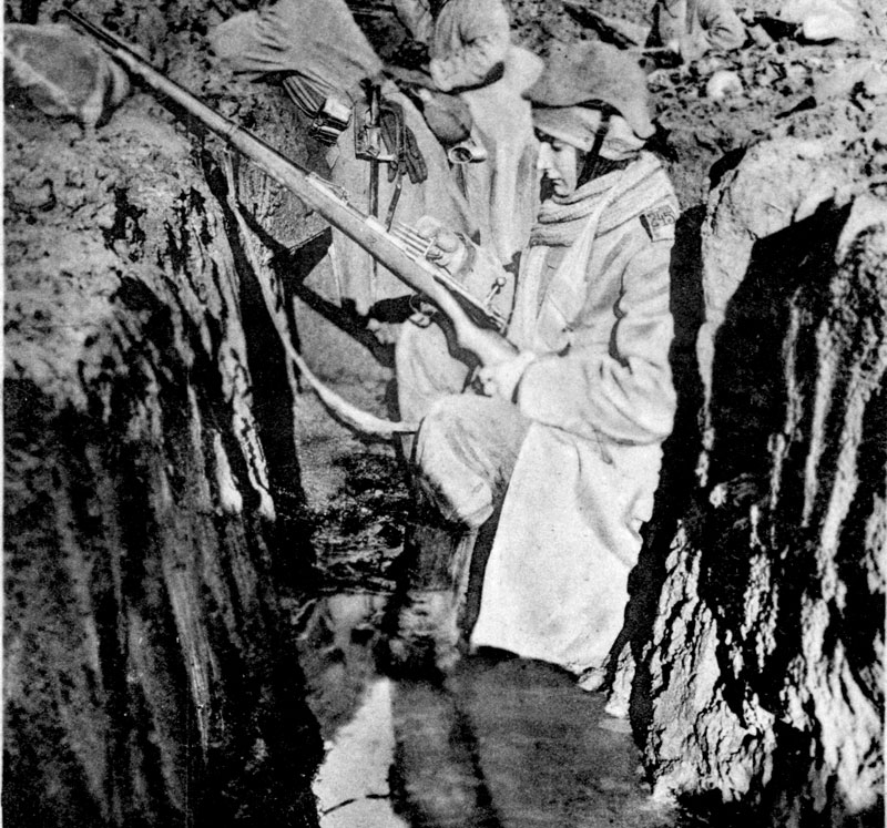 Udsnit af postkort med soldat i en vandfyldt skyttegrav, under billedet har Thyge Thygesen skrevet "naturtro stilling" (Historisk Arkiv for Haderslev Kommune)